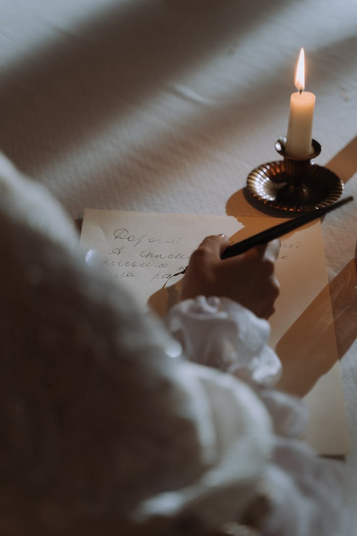 Elegant handwriting illuminated by a candle for a vintage, cozy ambiance.
